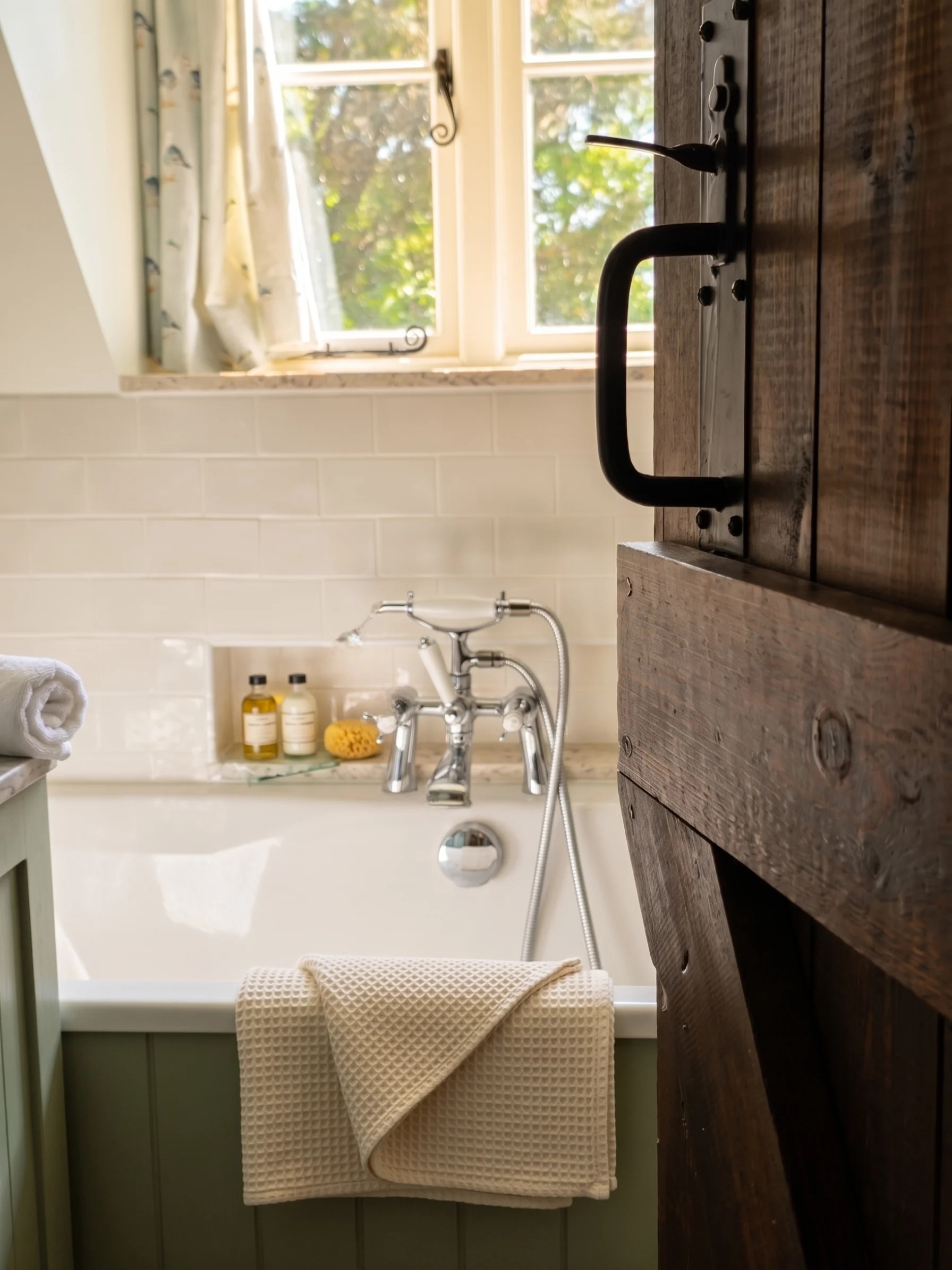 Roll-top bath with rustic barn door in a cottage bathroom