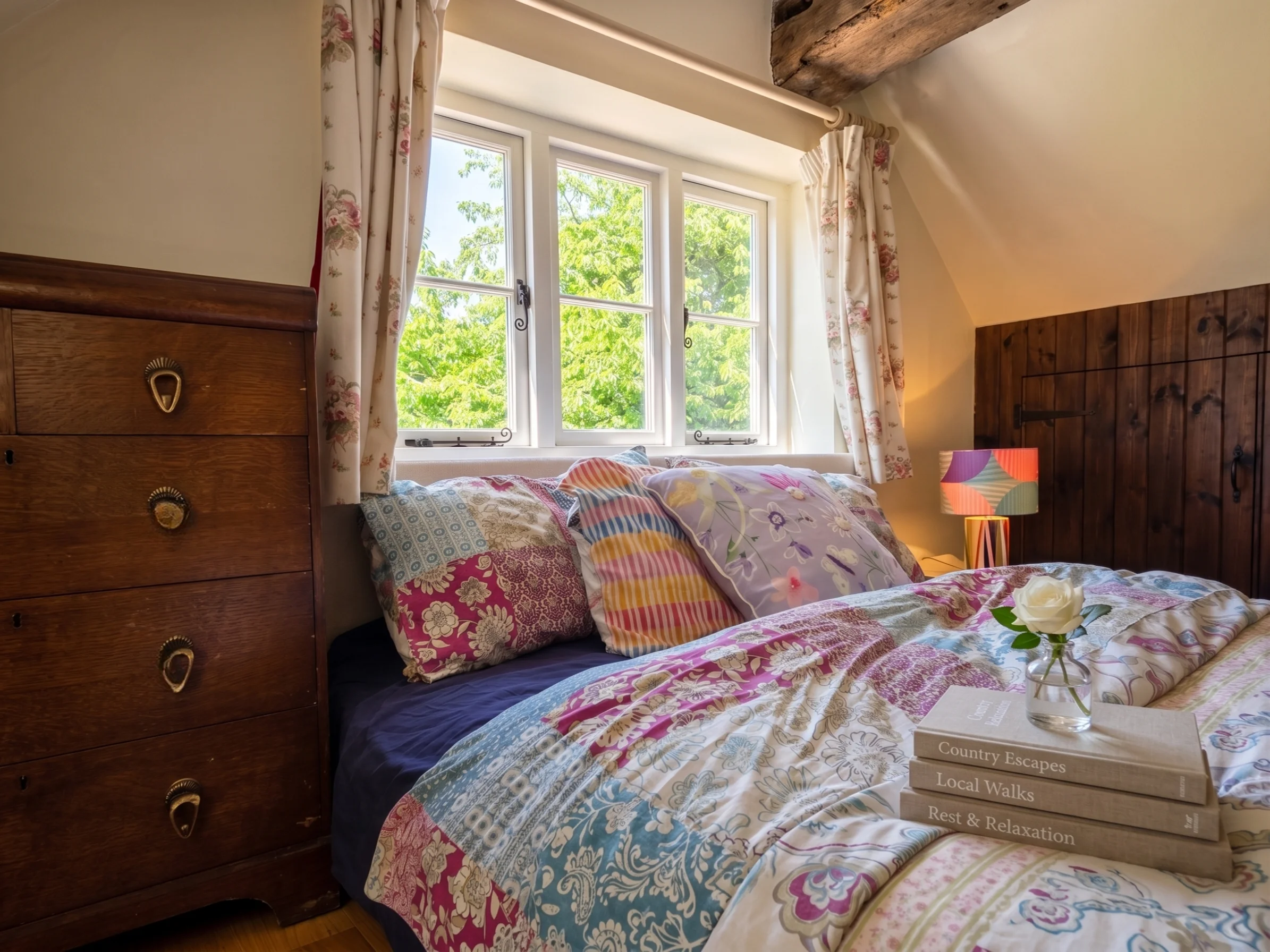 Cottage bedroom with patchwork quilt and antique dresser