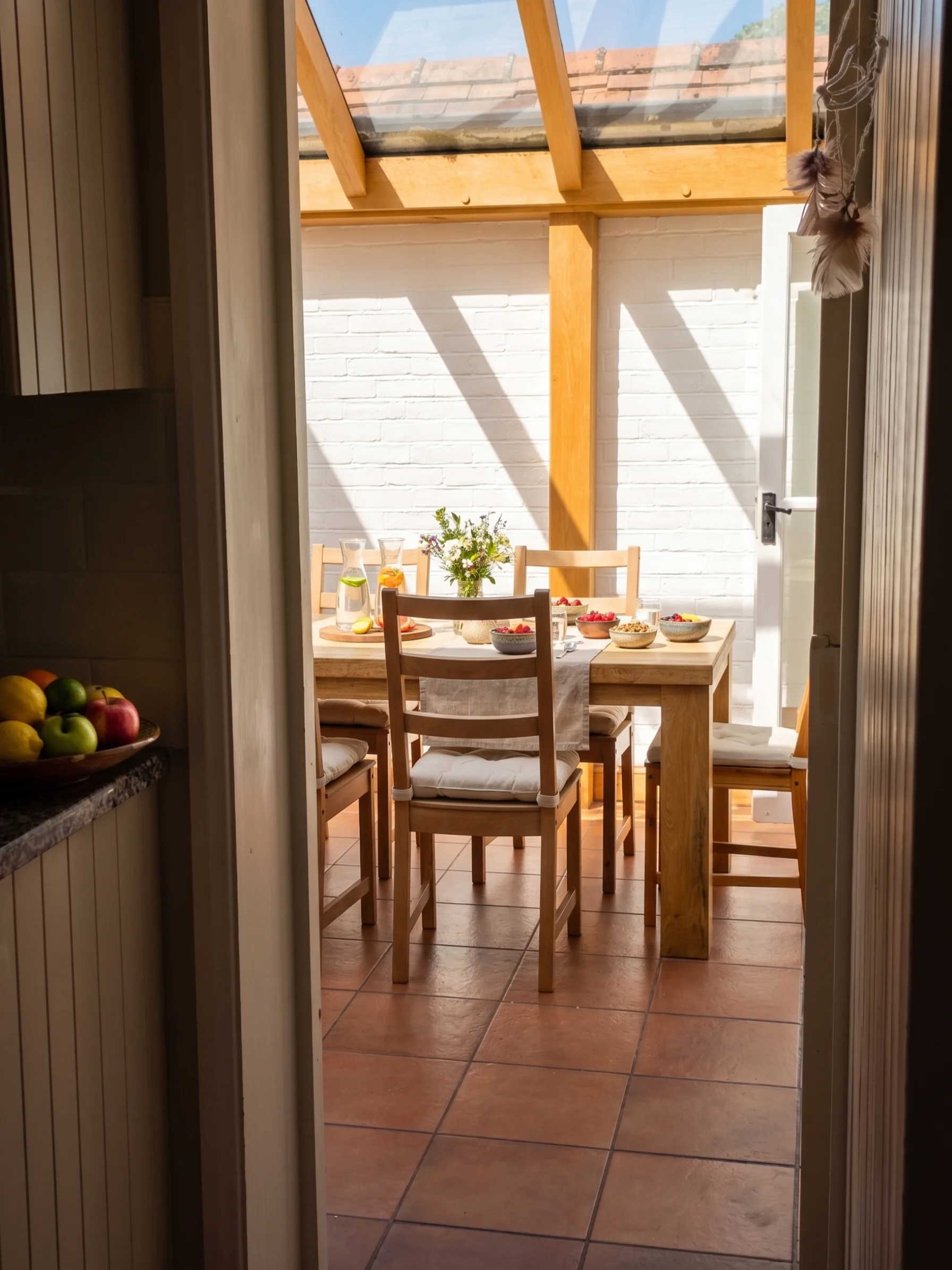 Sunlit conservatory dining area laid with fresh fruit